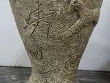 a stone vase with writing on it sitting on a table