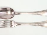 two spoons and a fork on a white surface