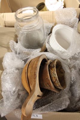 une boîte en carton contenant divers objets, notamment une cuillère en bois, un bocal, un bocal de sel et une cuillère en bois