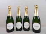 trois bouteilles de champagne posées sur une table l'une à côté de l'autre