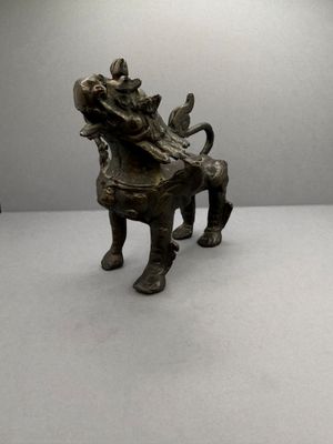 figurine en bronze représentant un chien avec un oiseau perché sur son dos