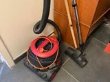 un vide et un aspirateur posés sur le sol d'une pièce