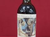 a bottle of red wine sitting on top of a red table