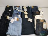 several pairs of men ' s jeans sitting on a table with price tags on them