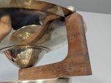 a silver bowl on a wooden stand on a table