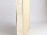 an old book sitting on top of a white table next to a white wall