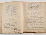 an old open book with writing on it sitting on a table
