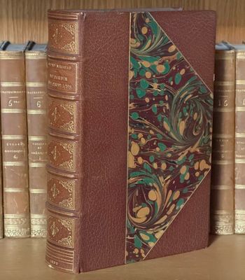 un livre posé sur une étagère à côté d'une pile de livres