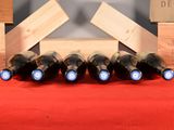 bottles of wine are lined up on a red table cloth