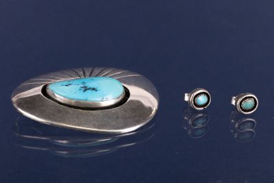 trois bijoux posés sur une surface bleue