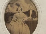 an old picture of a man and a woman sitting at a table