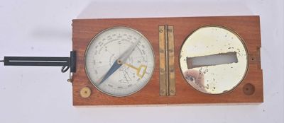 a wooden and metal clock with a barometer on top of it