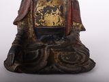 an image of a statue of a buddha sitting on a white surface