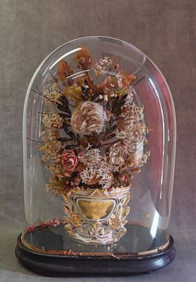 une cloche en verre contenant un bouquet de fleurs