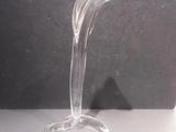 un vase en verre transparent muni d'une anse incurvée, posé sur une table
