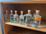 des bouteilles de gin posées sur une étagère en bois dans une pièce aux murs bleus