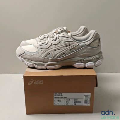 un gros plan sur une paire de baskets blanches posées sur une boîte