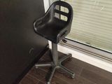 une chaise noire placée devant une fenêtre