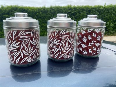 trois bocaux ornés de motifs rouges et blancs, posés sur le toit d'une voiture