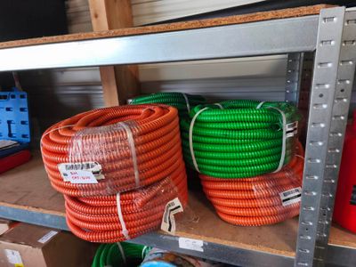 de nombreux tuyaux de différentes couleurs posés sur une étagère dans une pièce