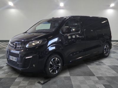 La camionnette noire est garée sur un sol en dalles à damier.