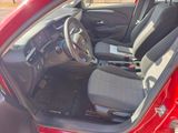 the interior of a red car with the door open and the driver ' s seat down