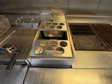 a kitchen with a stove, sink, and oven inside of it