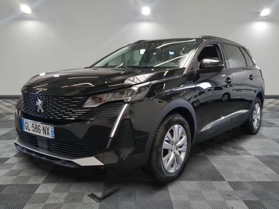 la voiture noire est garée sur un sol en damier dans le garage