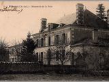 une vieille photo d'une grande maison avec une tour horloge