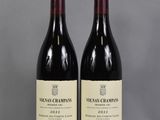 two bottles of wine sitting on top of a table next to each other
