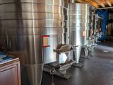 many stainless steel tanks lined up in a room