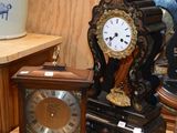 une horloge posée sur une table à côté d'un vase