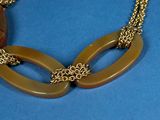 gold tone necklace with two oval links and a gold chain