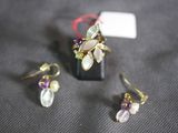 two pairs of earrings and a ring on a table