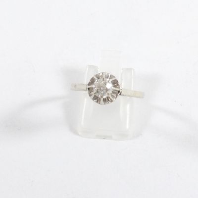 un gros plan d'une bague sertie d'un diamant sur un fond blanc