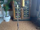 an old fashioned floor lamp with a candle on top of it