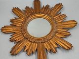 un miroir blanc en forme d'étoile rayonnante posé sur une table blanche
