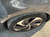a man standing next to a car with a broken tire