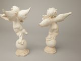 pair of white statues of cherenshes on pedestals against a gray background