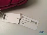 a pink purse with a price tag attached to it
