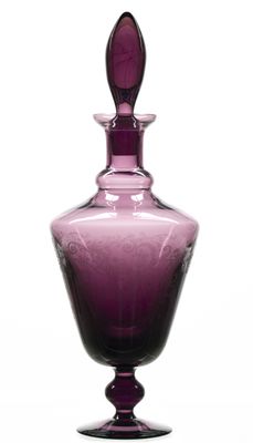 un vase en verre violet sur lequel repose une cuillère