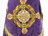a close up of a purple robe with a cross on it