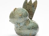 sculpture représentant un oiseau, réalisée en argile verte sur fond blanc
