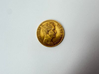 gros plan d'une pièce d'or sur une surface blanche