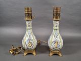 une paire de lampes anciennes en porcelaine ornées de motifs dorés et bleus