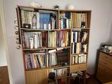 a book shelf in the corner of a bedroom with a bed and a dresser