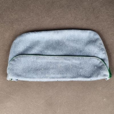 un gros plan d'un petit sac gris posé sur une surface marron
