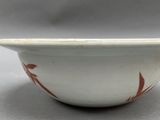 a white bowl with a red design on it