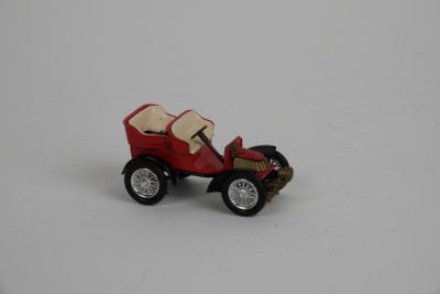 une petite voiture miniature posée sur une surface blanche