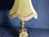 une lampe de table ancienne en laiton, avec un abat-jour blanc sur fond bleu